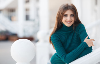 long haired brunette with a beautiful smile in a turquoise sweater